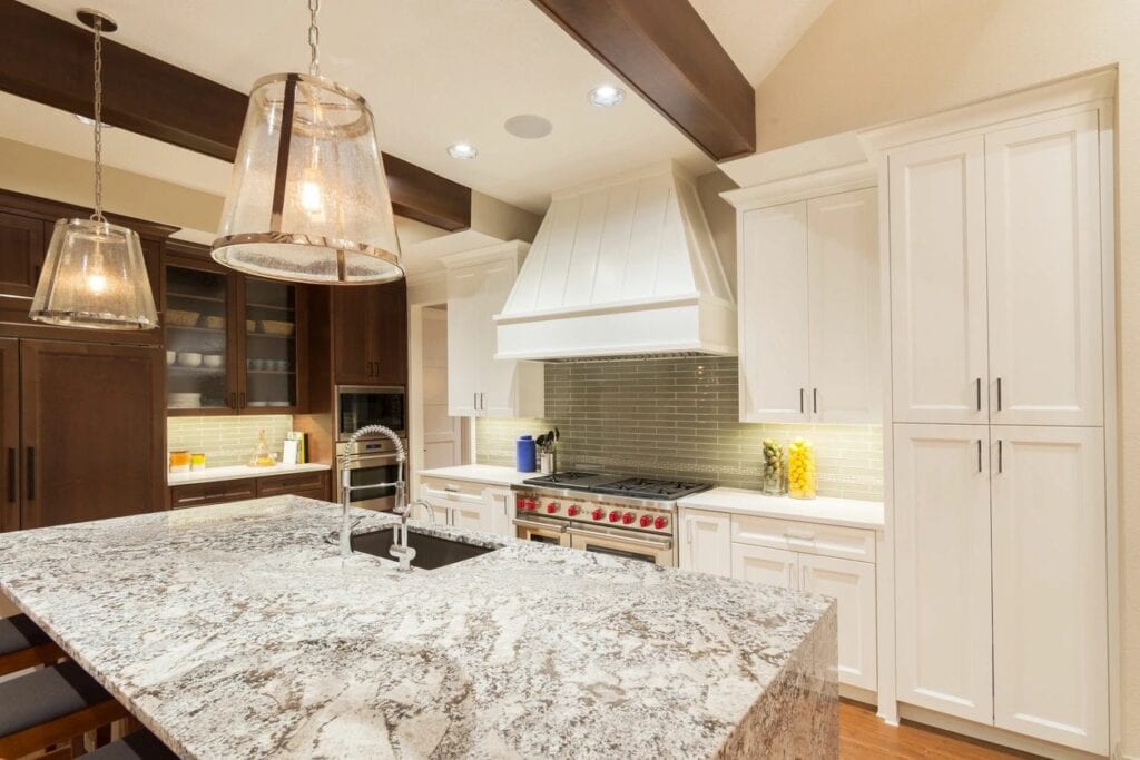 marble counter kitchen and a gas range with red knobs