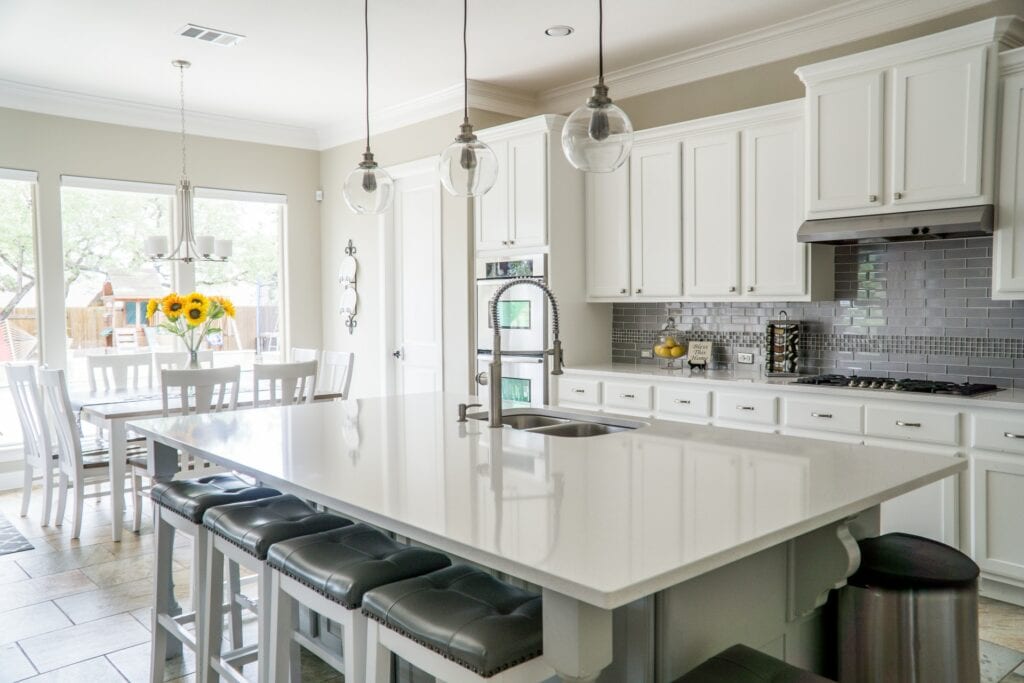 white kitchen with a spring faucet at the center